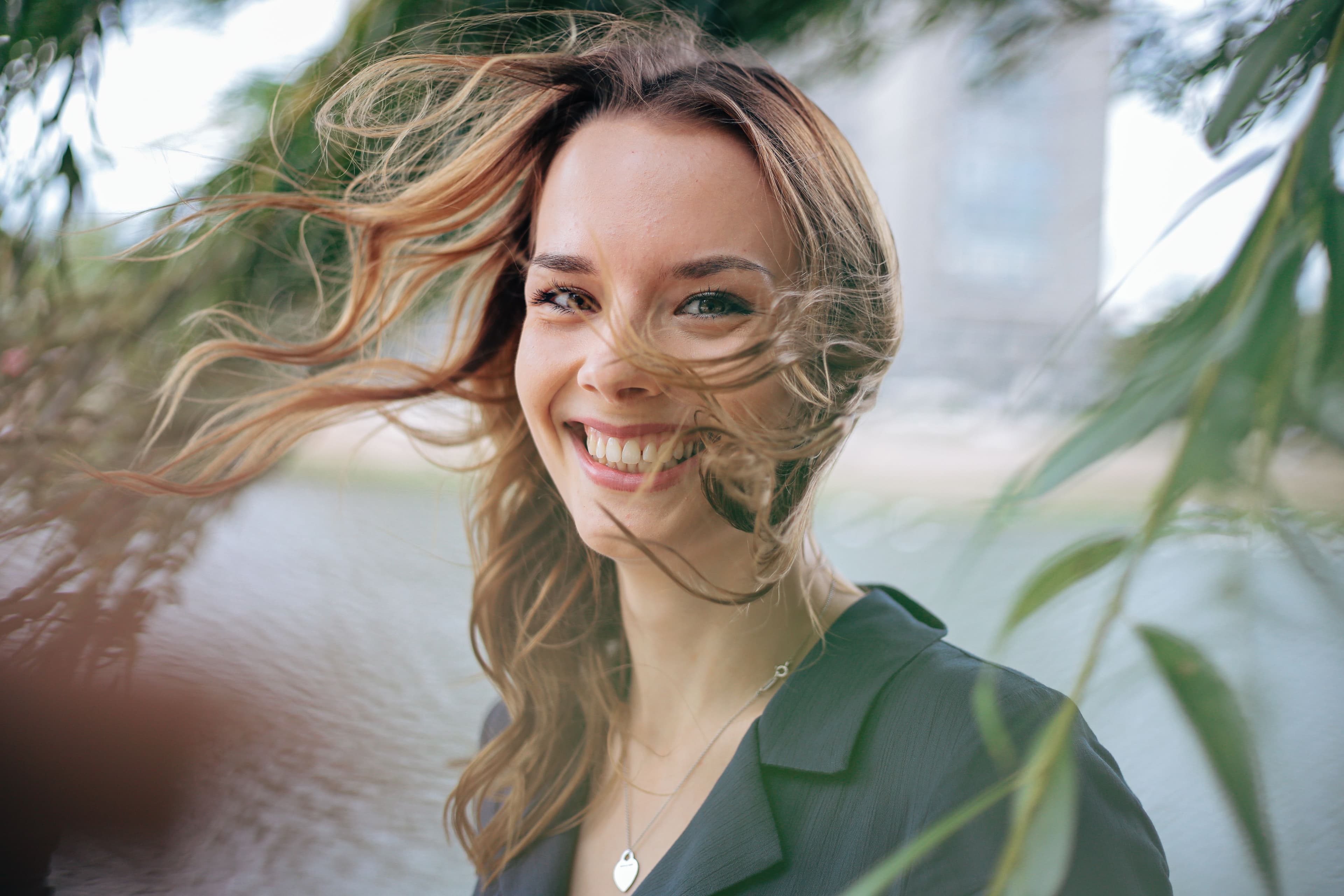 A person smiling outdoors in soft natural light.